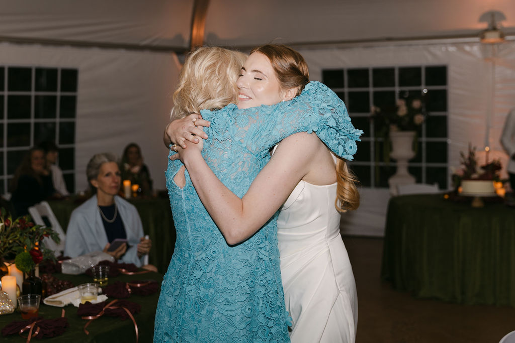 Bride hugging her mother during an emotional moment at a Hudson Gardens wedding reception