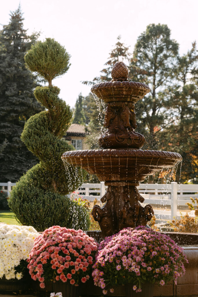 Water streaming from the beautiful fountain surrounded by florals at this Boulder, Colorado garden wedding venue 
