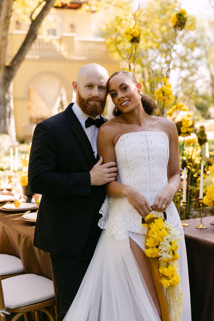 Bride and groom classic wedding portrait embracing one another and smiling at the camera 