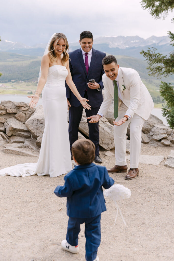 Ring bearer delivering the rings to the bride and groom at their mountain wedding ceremony
