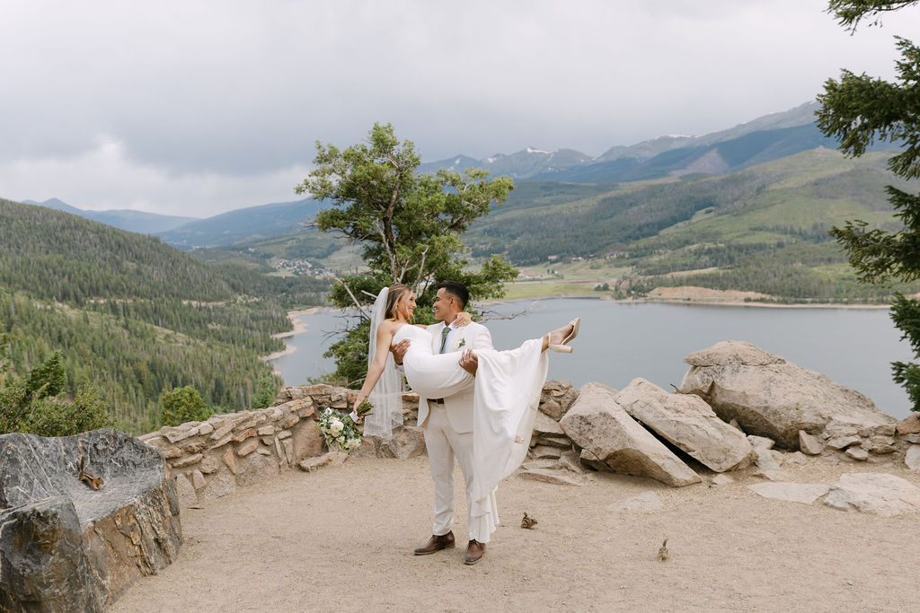 Groom carrying bride and spinning her around after their micro wedding ceremony at Sapphire Point Overlook