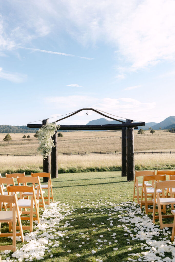 Outdoor ceremony aisle lined with white petals at Spruce Mountain Ranch’s mountain-view ceremony site.
