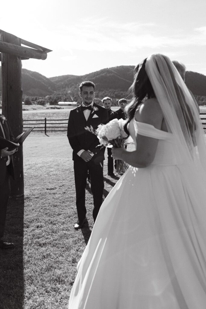 Bride approaching the ceremony arch during a Colorado luxury ranch wedding.