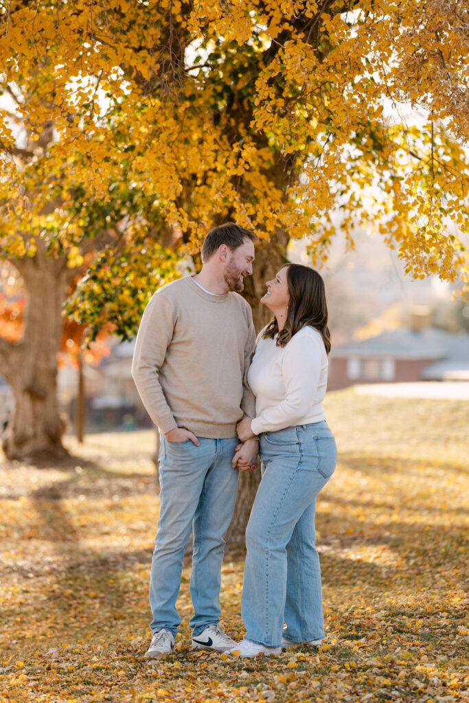 Couple standing together under fall foliage at Inspiration Point Park for their Denver engagement photos