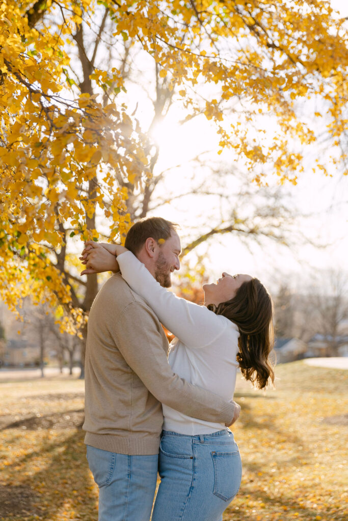 Couple laughing together under golden leaves at Inspiration Point Park in Denver.