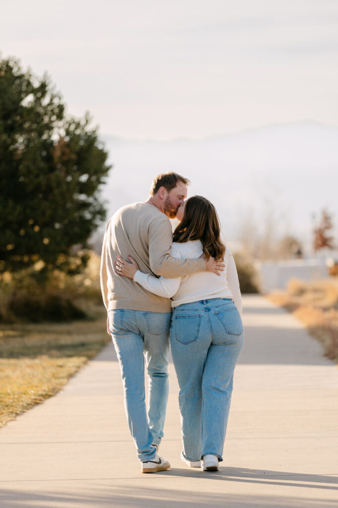 Couple walking away from the camera with mountain views during their Denver engagement photos