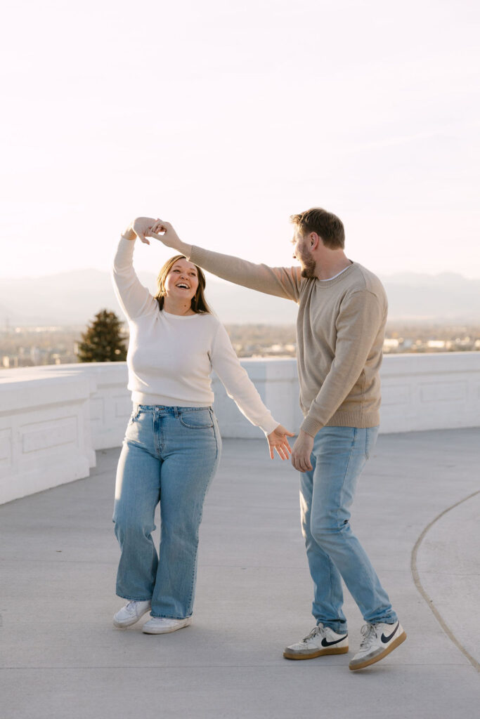 Couple dancing together on the overlook patio in Denver during their engagement photos.