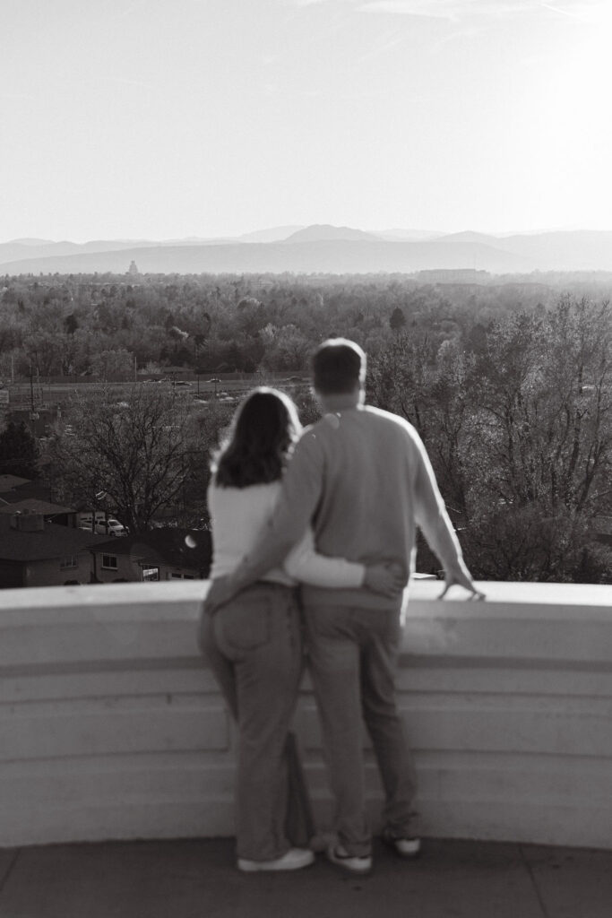 Back view of couple looking out over the Denver skyline and mountain views at Inspiration Point Park