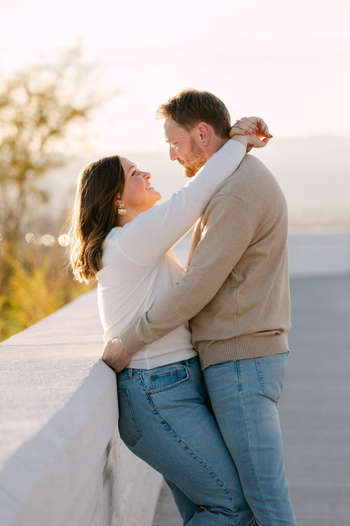 Couple embracing on the overlook wall with Denver city views behind them