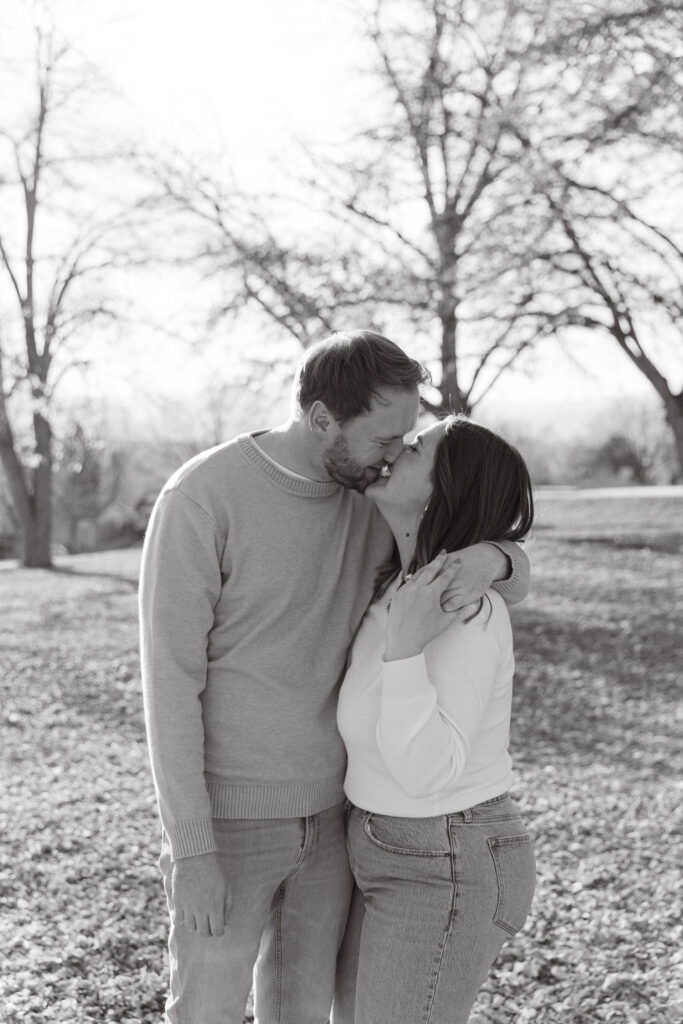 Romantic black and white photo of couple hugging under trees at Inspiration Point Park in Denver.