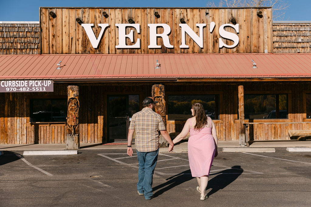 Couple walking hand-in-hand toward Vern’s Place for their Northern Colorado engagement photos.