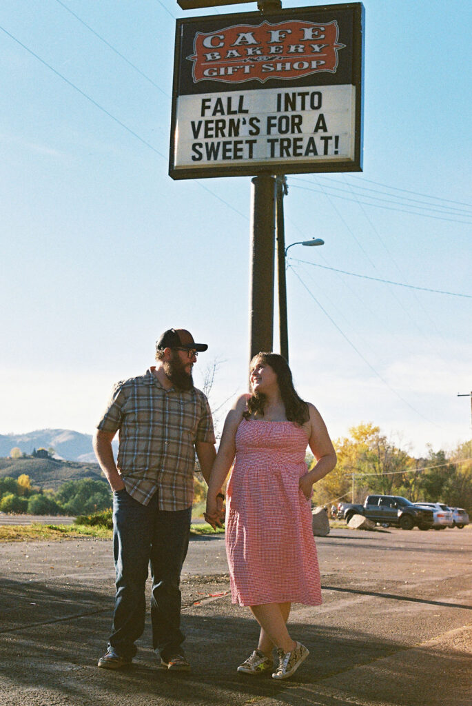 Couple standing beneath the Vern’s Place sign during their Northern Colorado engagement session.