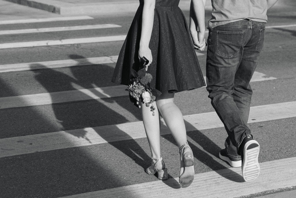 Black and white detail photo of Annelise holding her bouquet while walking in Old Town Fort Collins.