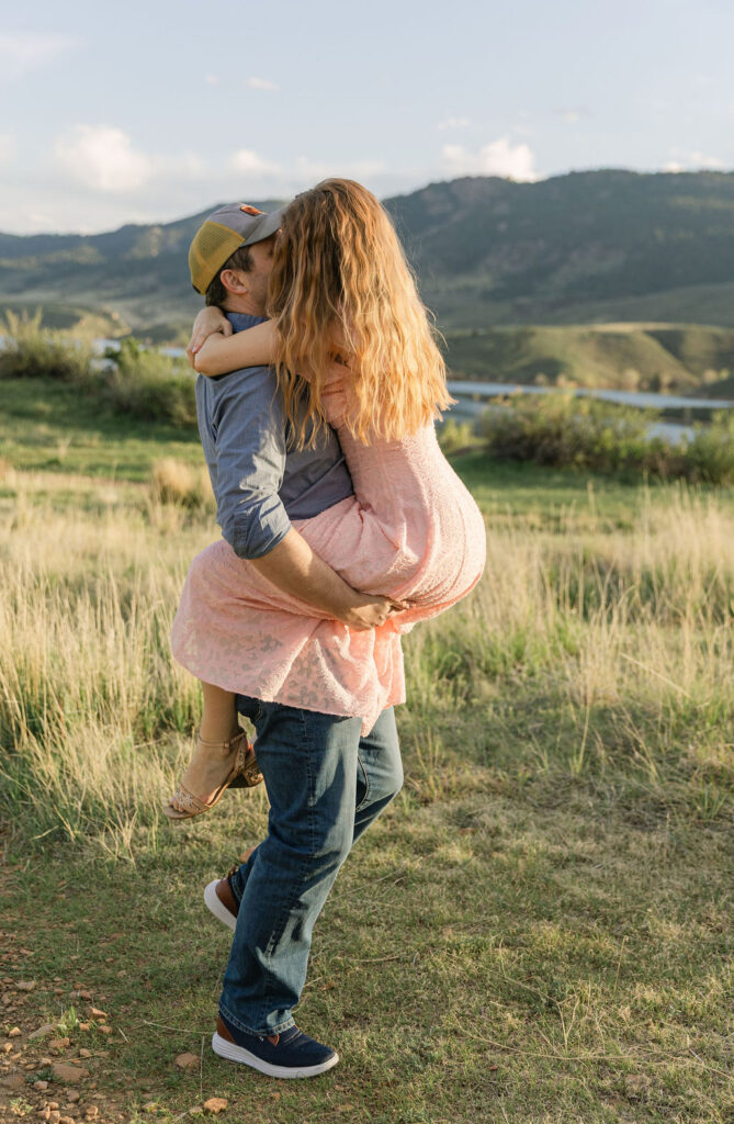 Ross lifting Annelise as she laughs during their Horsetooth Reservoir engagement shoot.