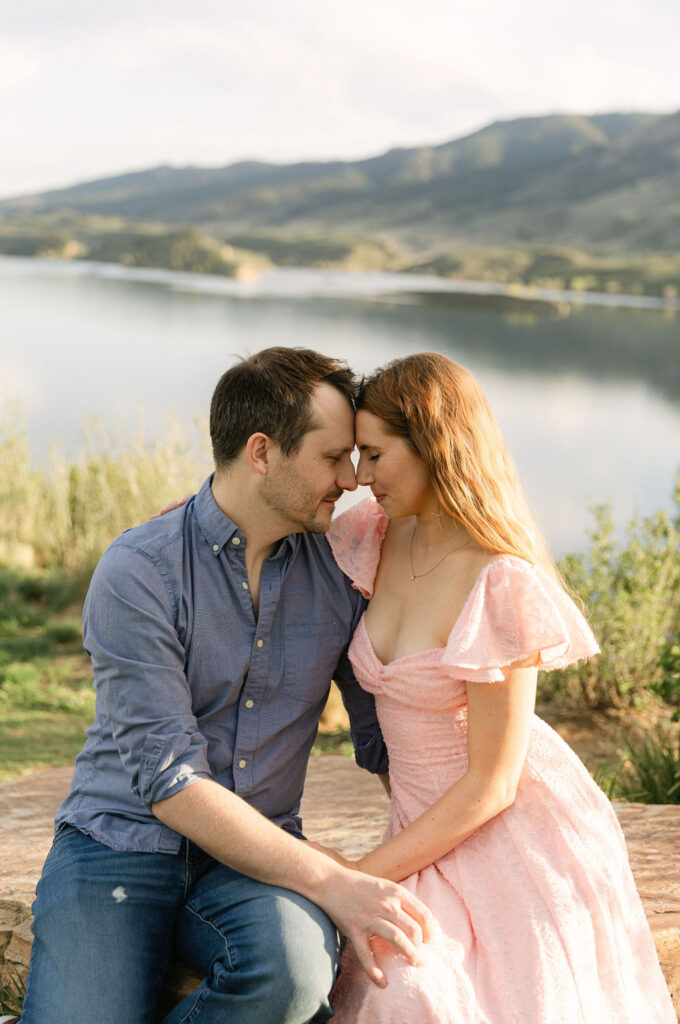 Annelise and Ross sitting closely together with Horsetooth reservoir in the background.