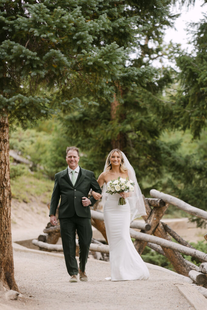 Father walking the bride down the aisle at her outdoor microwedding in Colorado