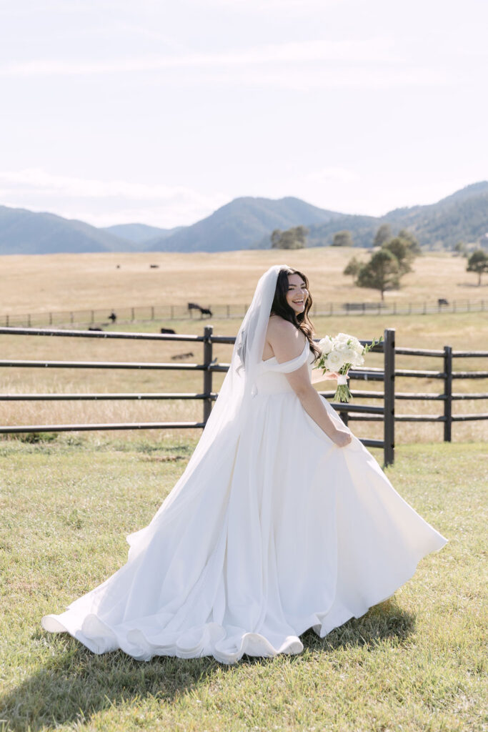Candid wedding photo of bride walking in the field at Spruce Mountain Ranch in Larkspur, Colorado in her ball gown wedding dress 