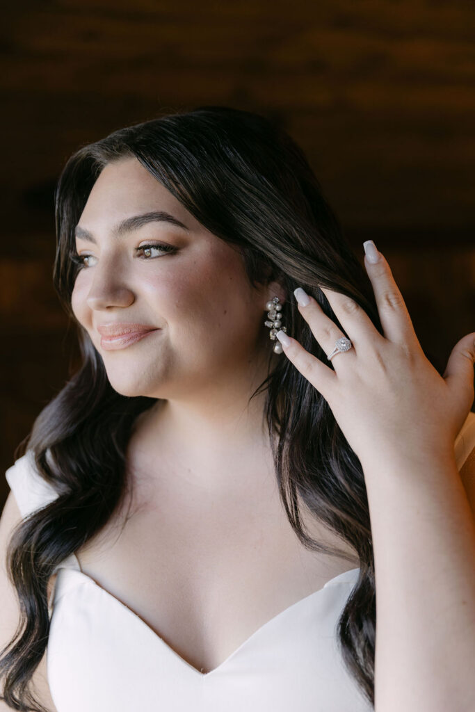 Bride touching her hair during soft bridal portraits inside the lodge at Spruce Mountain Ranch.