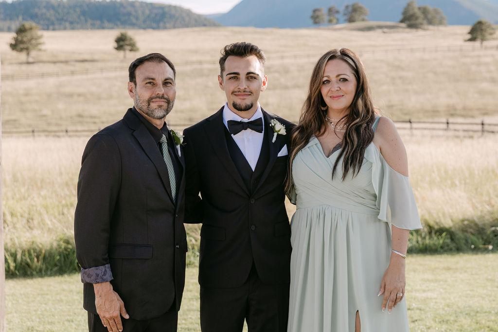 Groom with his parents at the upper ranch ceremony site at spruce mountain ranch wedding venue 