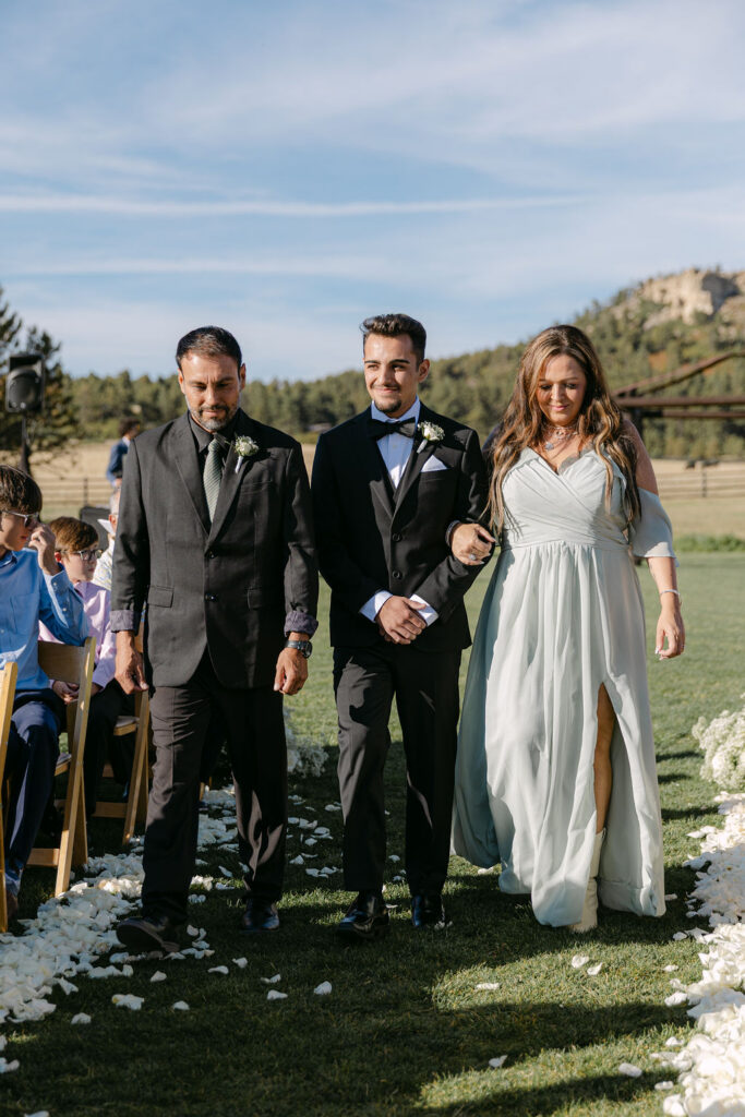 Processional with groom and family walking down the aisle at Spruce Mountain Ranch.