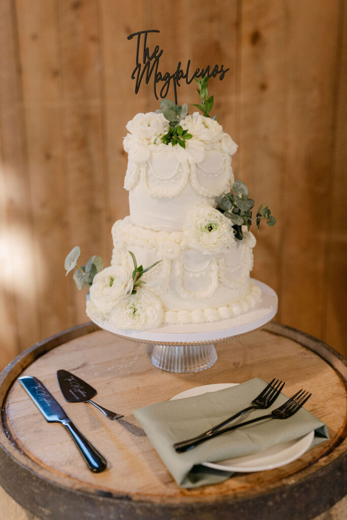 Three-tier white wedding cake with floral accents at Spruce Mountain Ranch.