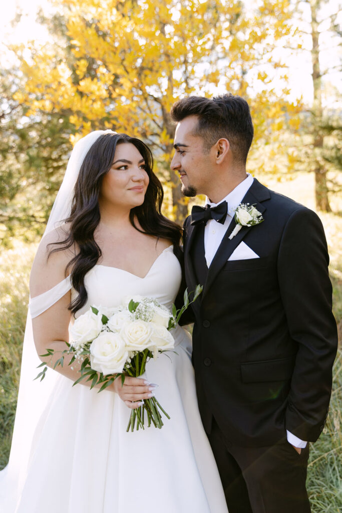 Bride smiling up at groom during golden hour portraits in Colorado.