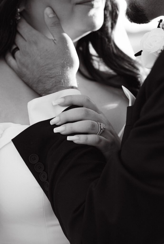 Close-up ring shot of bride and groom's hands during golden hour portraits.