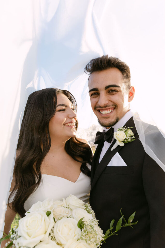 Bride and groom smiling under the veil during golden hour portraits at Spruce Mountain Ranch.