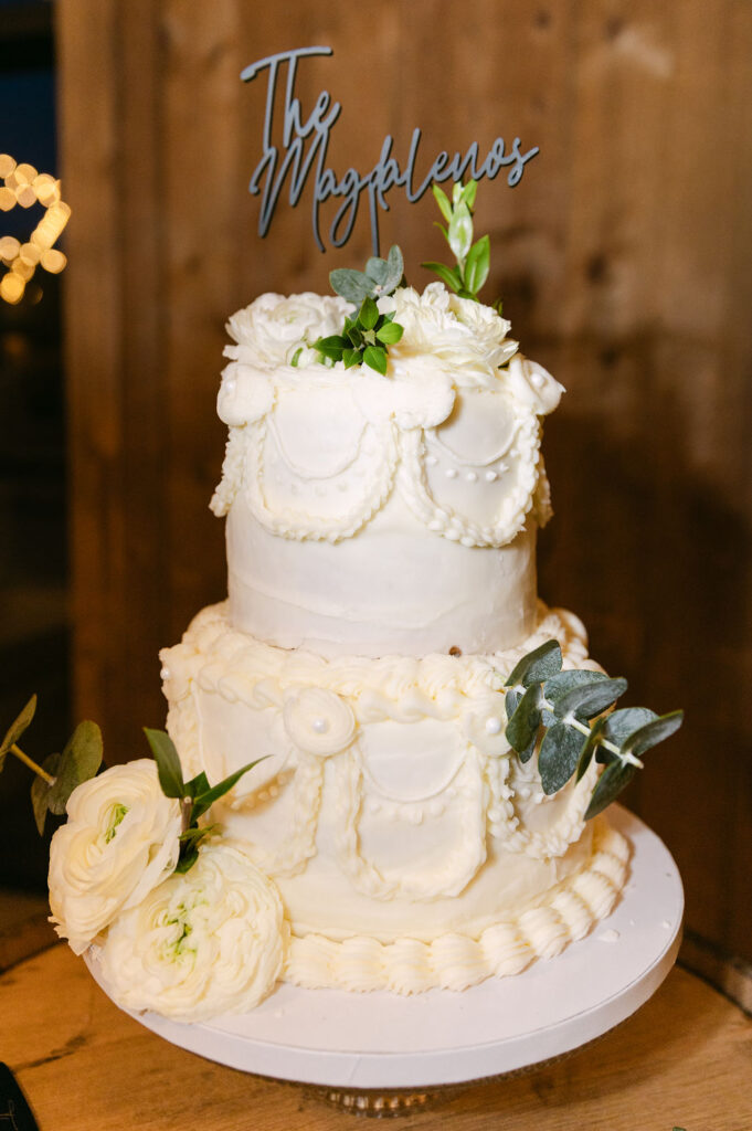 Three-tier white wedding cake with floral accents at Spruce Mountain Ranch.