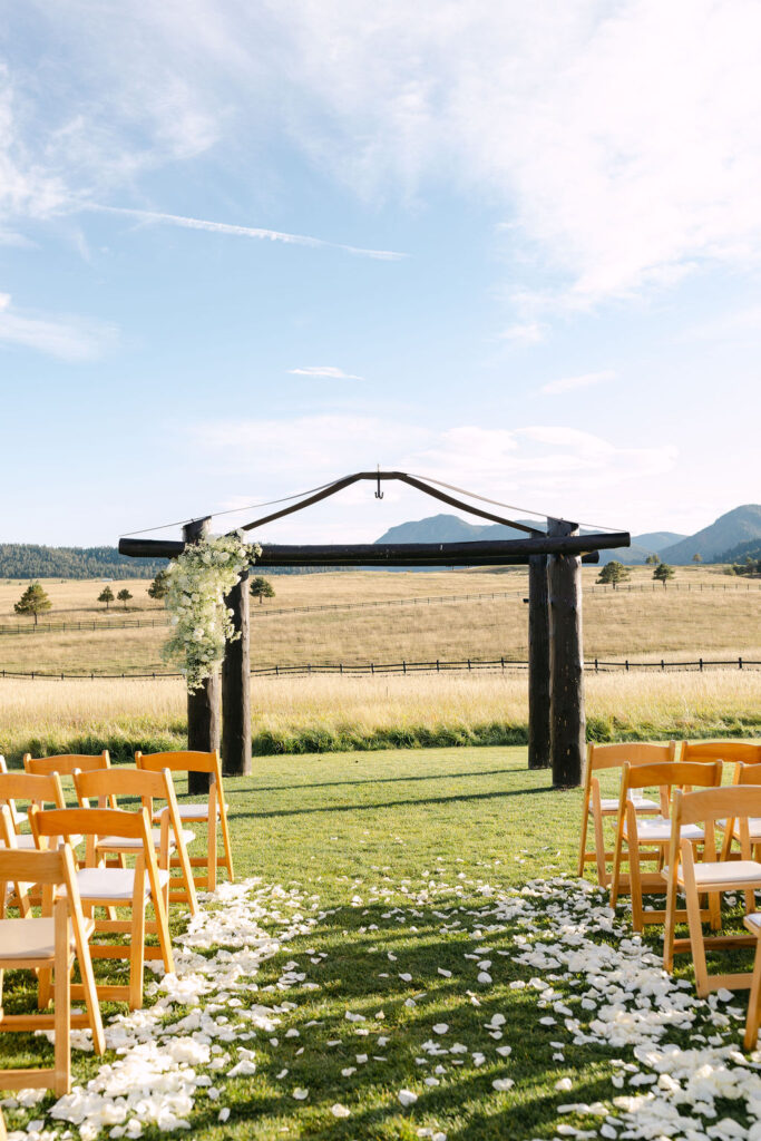 Outdoor ceremony aisle lined with white petals at Spruce Mountain Ranch’s mountain-view ceremony site.