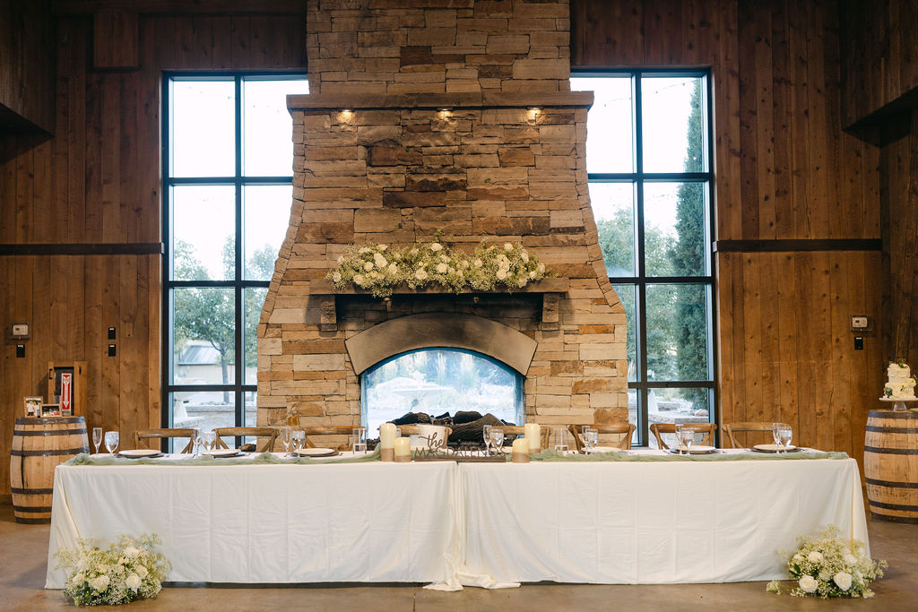 Head table styling in front of stone fireplace inside the lodge at Spruce Mountain Ranch.