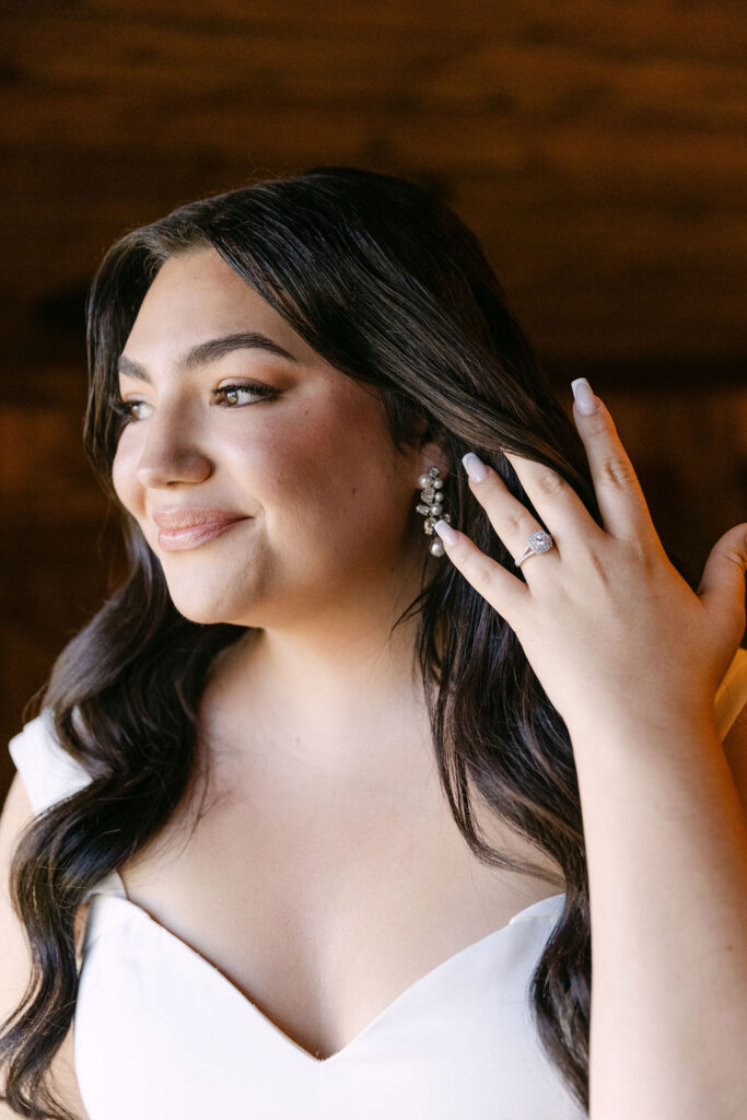 Bride touching her hair during soft bridal portraits inside the lodge at Spruce Mountain Ranch.