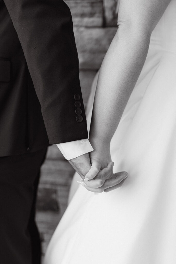 Close-up of couple holding hands during their luxury Colorado wedding.