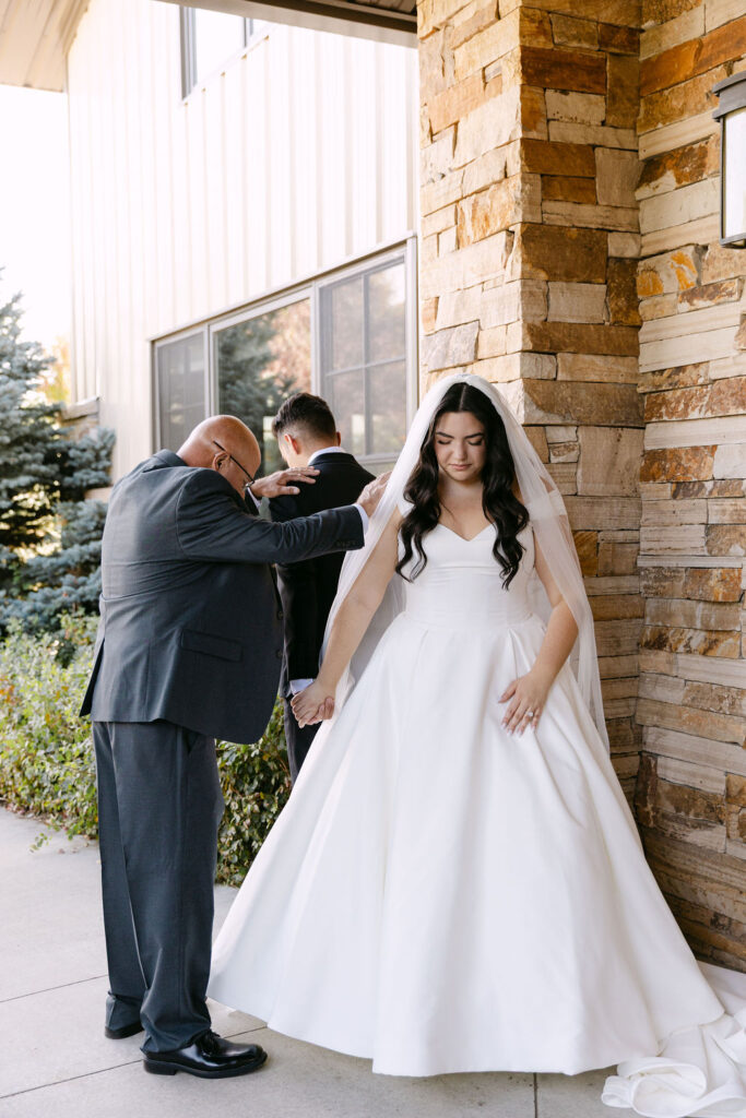 Bride and groom praying with their pastor before their colorado mountain wedding ceremony.