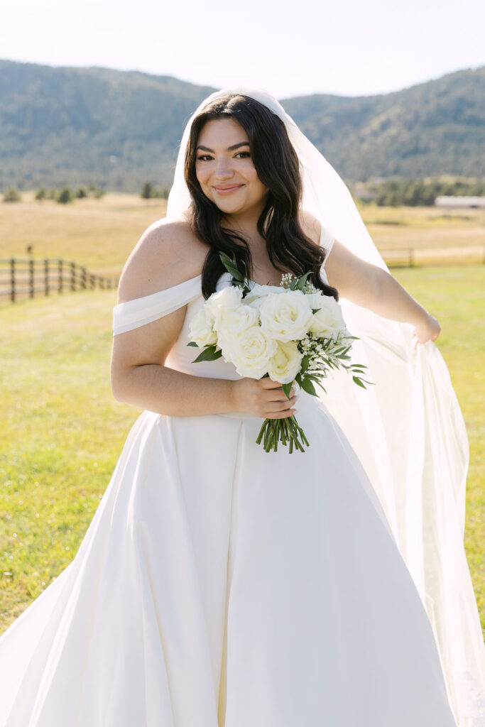 Bride holding bouquet for portraits near the lodge at Spruce Mountain Ranch.