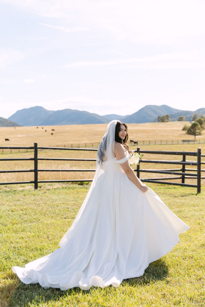 Bride walking with her bouquet in the fields at Spruce Mountain Ranch.