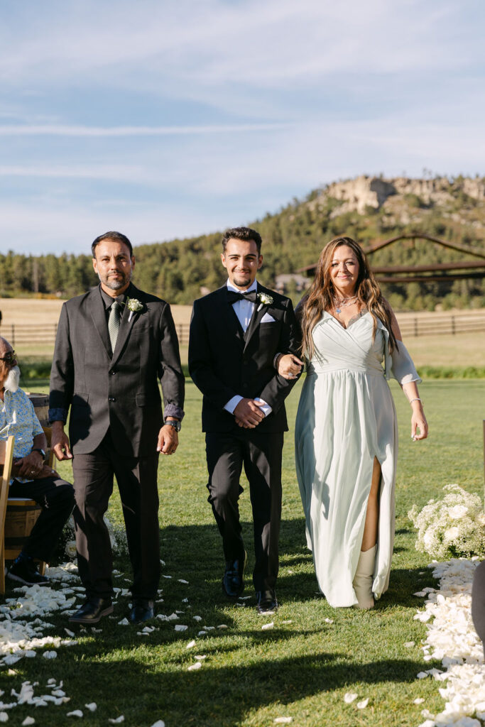 Processional with groom and family walking down the aisle at Spruce Mountain Ranch.