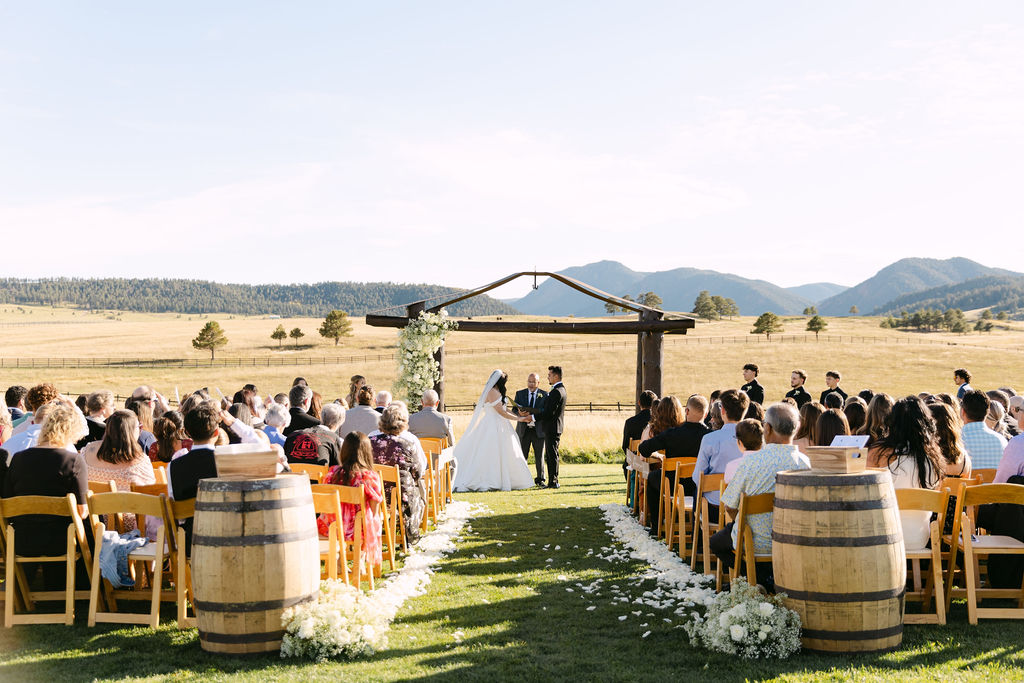 A wide view of a Spruce Mountain Ranch wedding ceremony at the upper ranch in Larkspur, Colorado