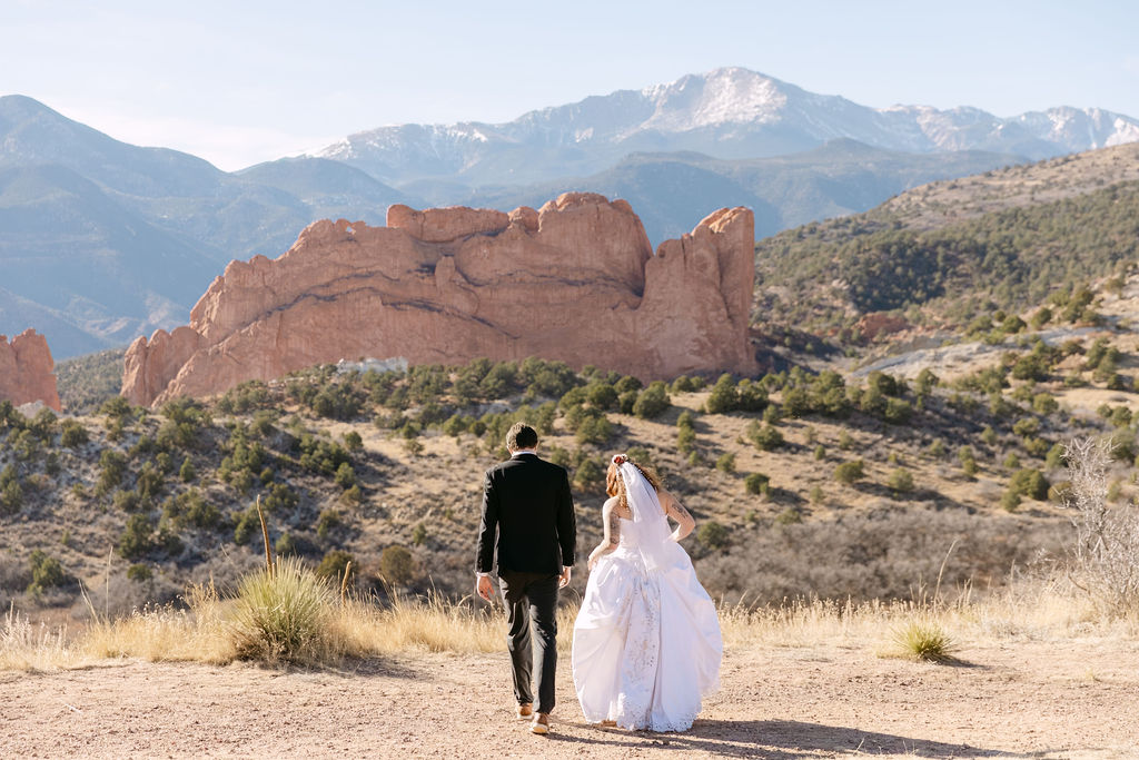 Scenic elopement location in Colorado Springs with the bride and groom walking towards the mountains during their photos
