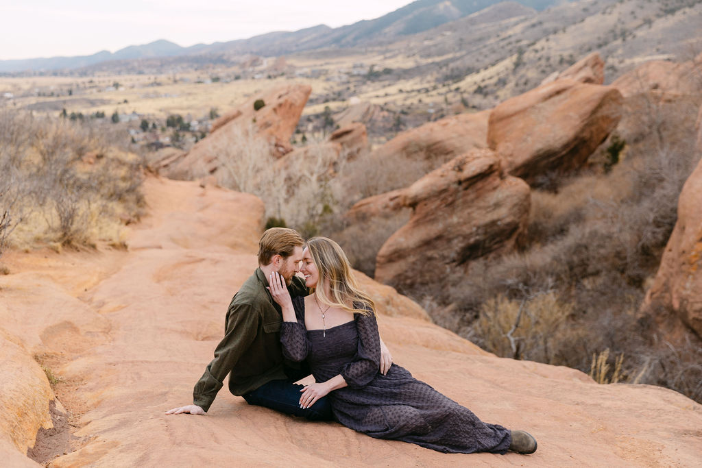 Romantic, classic engagement photo at Red Rocks Park laying on the rocks 