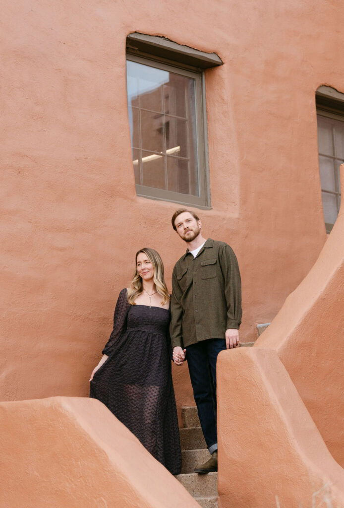 Couple posing stylishly on stairs at The Trading Post at Red Rocks Park in Morrison, Colorado 