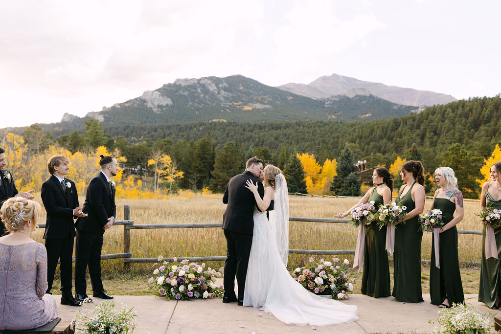 The couple shares a kiss during the outdoor ceremony at Wild Basin Lodge in Allenspark, Colorado, in Rocky Mountain National Park.
