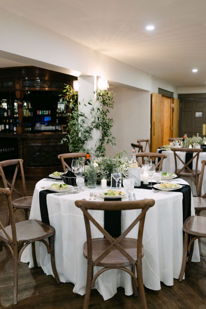 A round reception table with greenery and place settings inside Wild Basin Lodge in Allenspark, Colorado, within Rocky Mountain National Park.