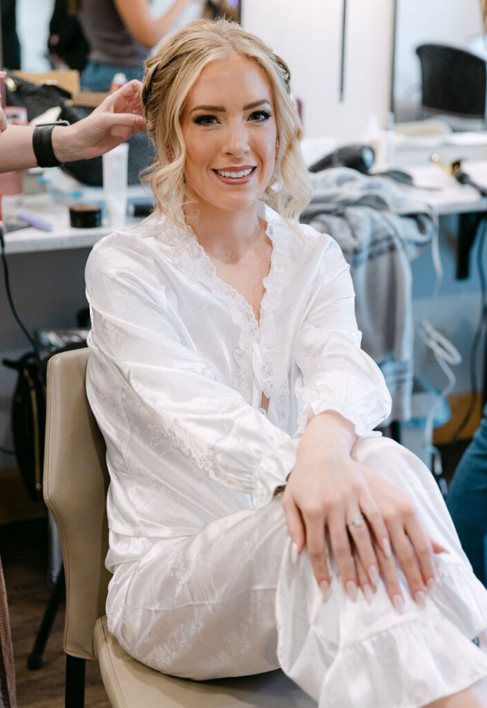 The bride smiles while getting ready indoors at Wild Basin Lodge in Allenspark, Colorado, in Rocky Mountain National Park.