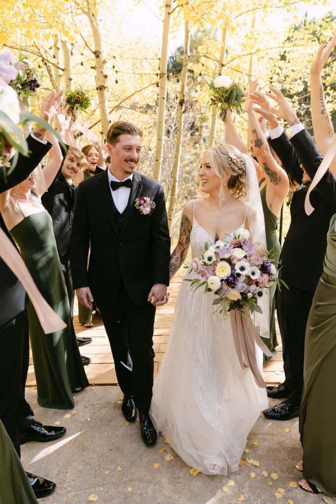 The couple walks back down the aisle surrounded by the wedding party.