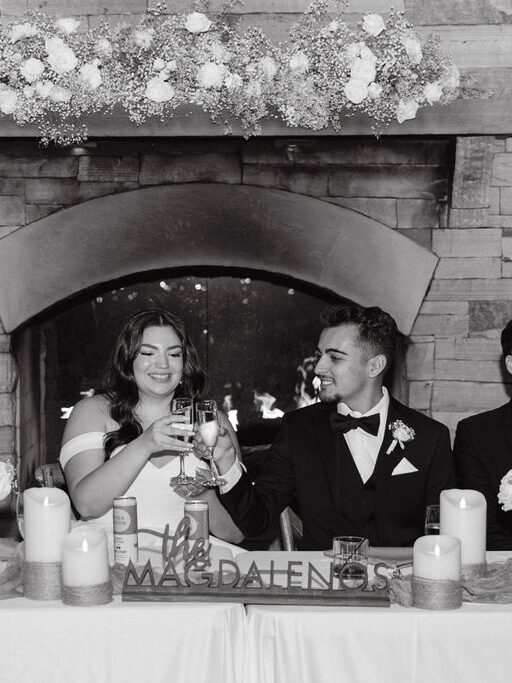 Black and white candid reception photo at Spruce Mountain Ranch of bride and groom cheersing during heartfelt toasts